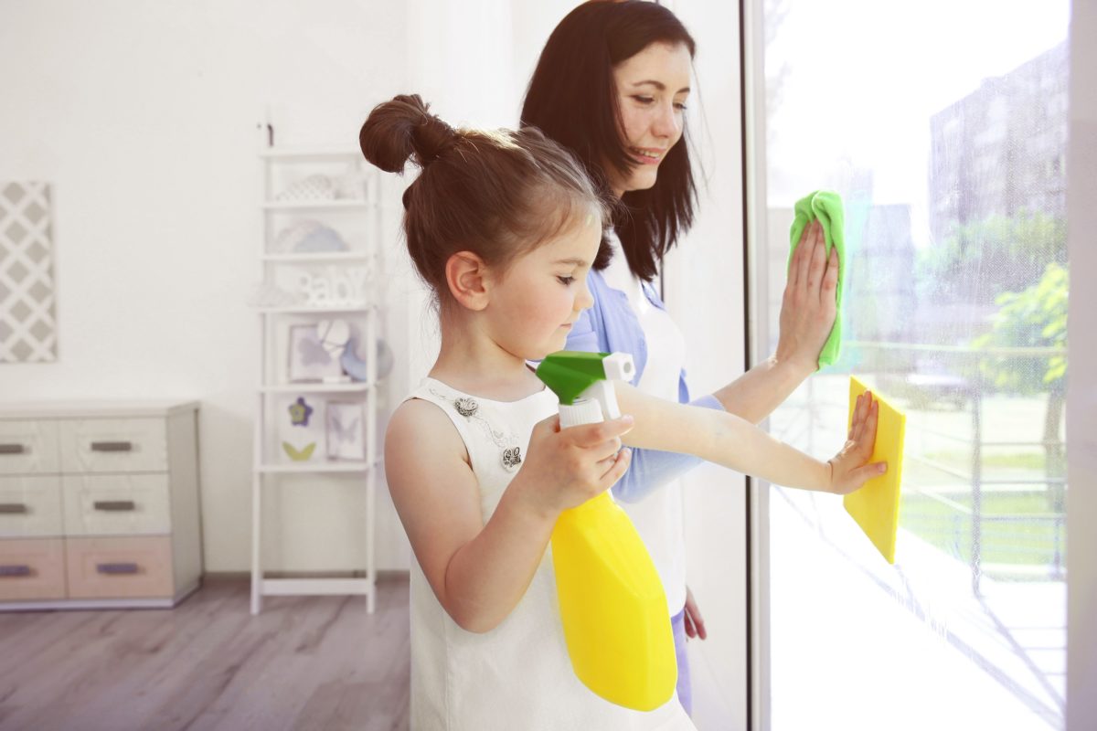 Daughter and mother cleaning window together