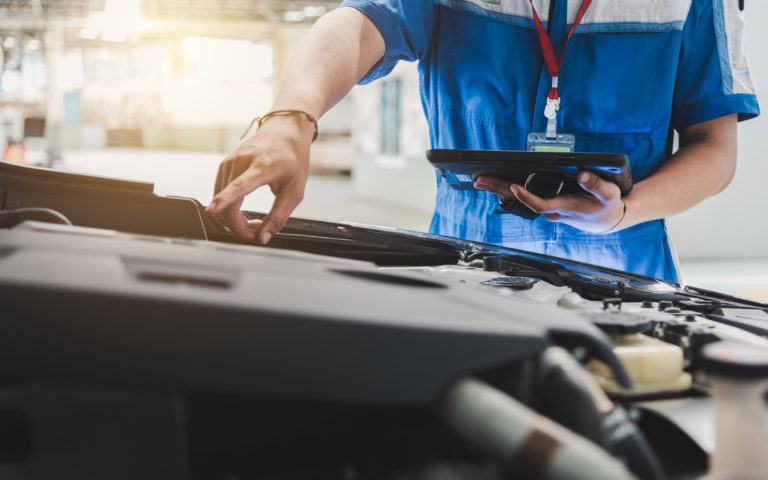 Auto mechanic uses the tablet to check.