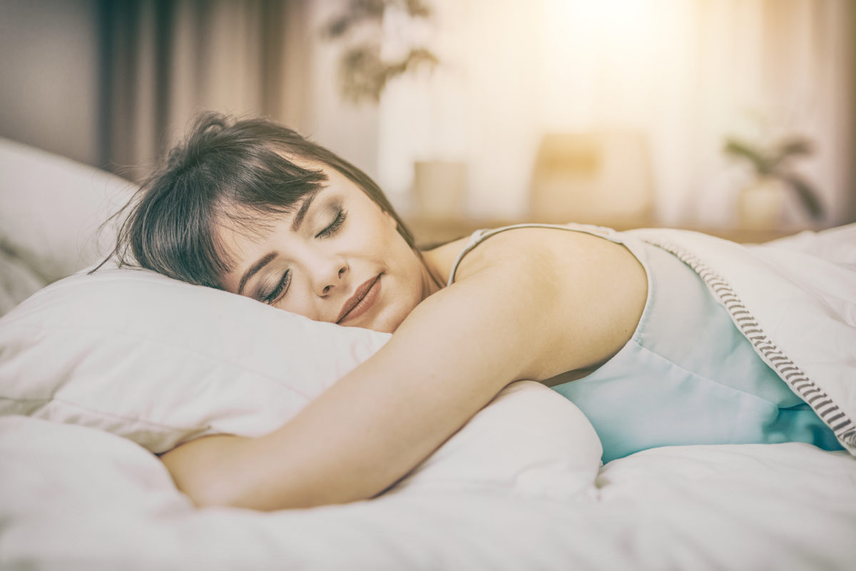 Beautiful young woman sleeping on a bed in the bedroom.