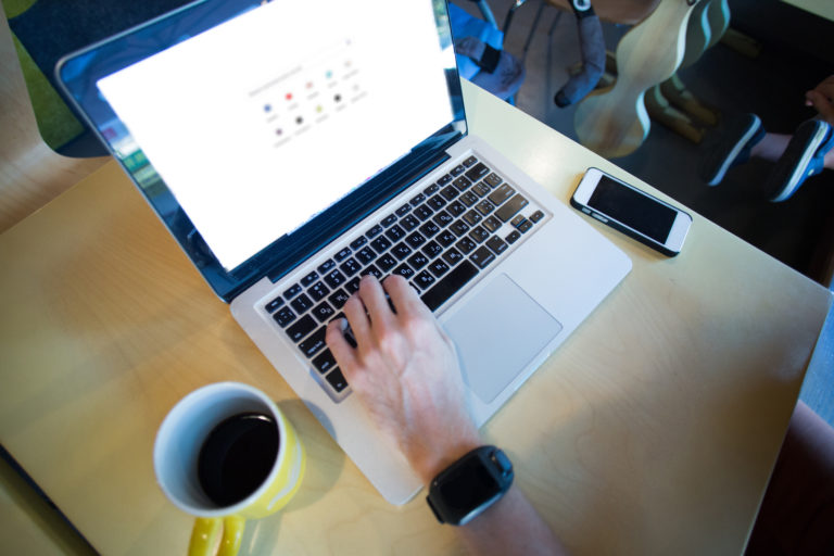 Cropped view of man using laptop with google website on screen