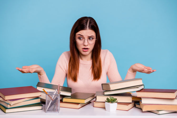 Portrait of her she nice attractive confused unsure uncertain doubtful girl preparing exam test subject 1 September at work place station isolated over bright vivid shine blue background