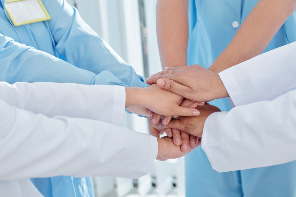 Doctors and nurses stacking hands