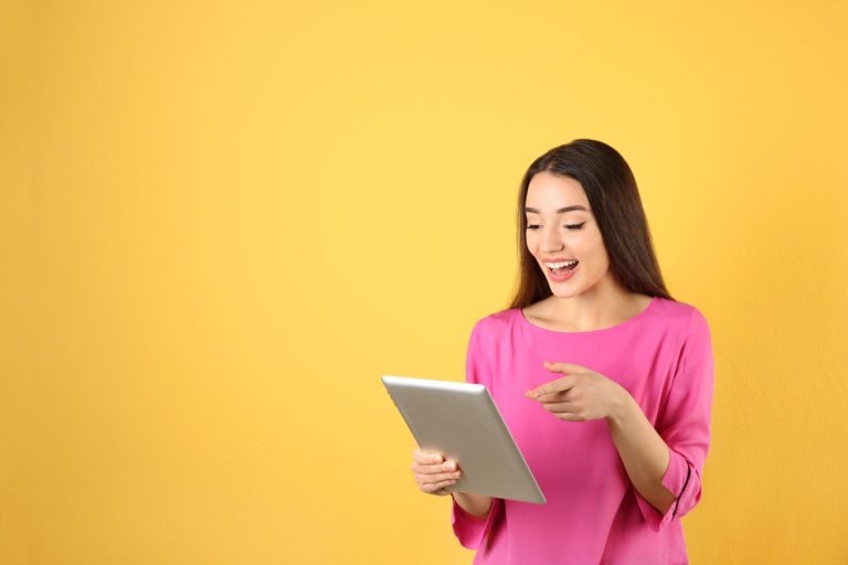 Woman using tablet for video chat on color background. Space for text