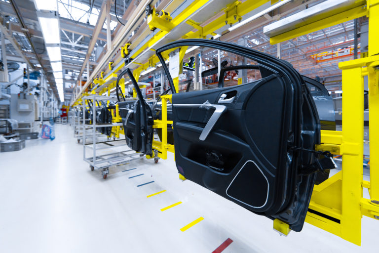 Preparation for installation of body part in car factory. door from car on production line
