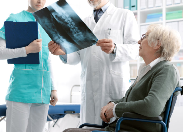 Doctor checking a senior female patient's x ray image during a visit at the hospital, injury and osteoporosis concept
