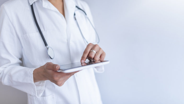 Portrait of female doctor using her digital tablet in the office.