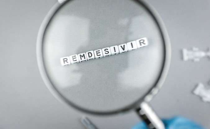Magnifying glass on alphabet dices with the word Remdesivir a possible treatment for Corona Virus