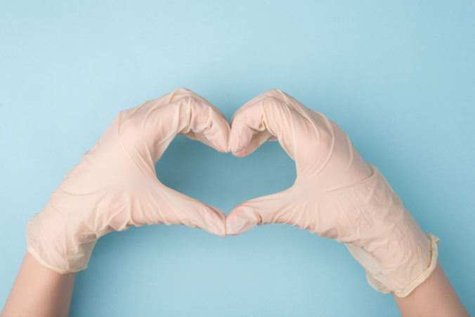 Save life concept. Cropped top above overhead close up photo of hands making giving shape of heart with fingers isolated over blue background