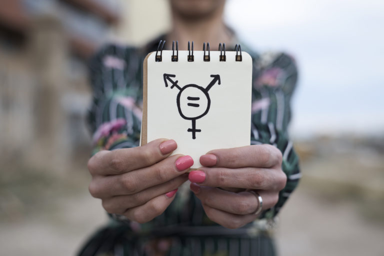 Woman shows notepad with a transgender symbol