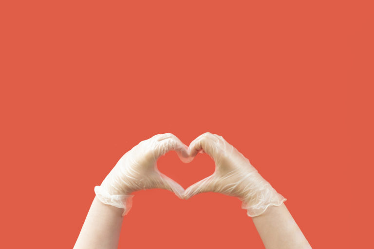 Hands wearing latex gloves creating a heart shape