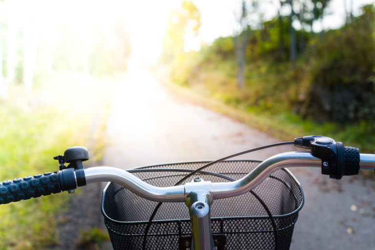 Red retro bike on a cycle path with sunlight