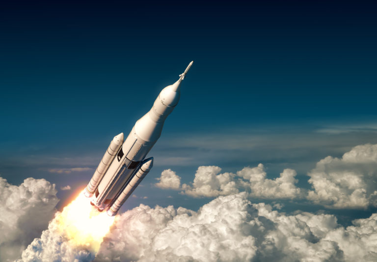 Flight Of Big Carrier Rocket Above The Clouds