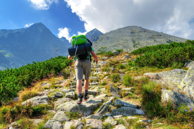 Hiker in the mountains. A tourist on tne trail with Lomnicky Stit in the bakcground. Situation in High Tatra Mountains, Slovakia.
