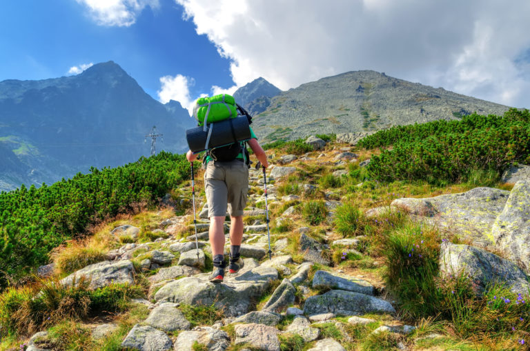 Hiker in the mountains. A tourist on tne trail with Lomnicky Stit in the bakcground. Situation in High Tatra Mountains, Slovakia.