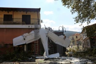 A small plane lays on a building after a crash in the village of Proti, near Serres town, northern Greece, on Monday, Aug. 3, 2020. The single-engine plane crashed on Monday morning into the front of a small building but no injuries were reported and the pilot of the Cessna aircraft is well.