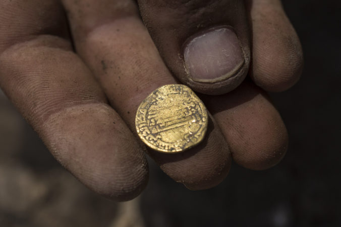 Israeli archaeologist Shahar Krispin displays a gold coin that was discovered at an archeological site in central Israel, Tuesday, Aug 18, 2020. Israeli archaeologists have announced the discovery of a trove of early Islamic gold coins during recent salvage excavations near the central city of Yavn Tel Aviv. The collection of 425 complete gold coins, most dating to the Abbasid period around 1,100 years ago, is a &quot;extremely rare&quot; find. (AP Photo/Sipa Press, Heidi Levine, Pool)