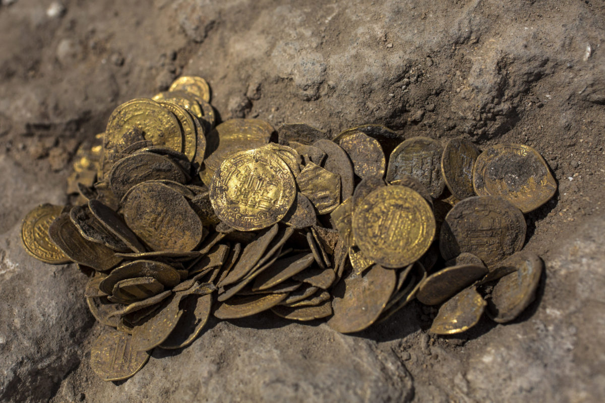 A hoard of gold coins that was discovered at an archeological site in central Israel, Tuesday, Aug 18, 2020. Israeli archaeologists have announced the discovery of a trove of early Islamic gold coins during recent salvage excavations near the central city of Yavn Tel Aviv. The collection of 425 complete gold coins, most dating to the Abbasid period around 1,100 years ago, is a "extremely rare" find. (AP Photo/Sipa Press, Heidi Levine, Pool)