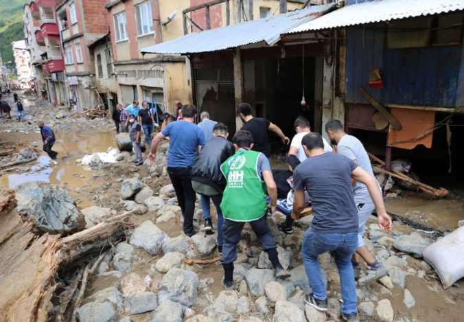 People carry a rescued person from the scene after floods caused by heavy rain in the mountain town of Dereli in Giresun province, along Turkey