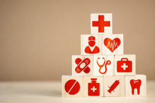 Wooden cubes stacking of healthcare medicine and hospital icon on table.Health care insurance business and investment.