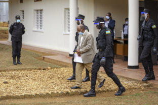 Paul Rusesabagina, center, whose story inspired the film "Hotel Rwanda", is led out in handcuffs from the Kicukiro Primary Court in the capital Kigali, Rwanda Monday, Sept. 14, 2020. A Rwandan court on Monday charged Paul Rusesabagina with terrorism, complicity in murder, and forming an armed rebel group, while Rusesabagina declined to respond to all 13 charges, saying some did not qualify as criminal offenses and saying that he denied the accusations when he was questioned by Rwandan investigators.
