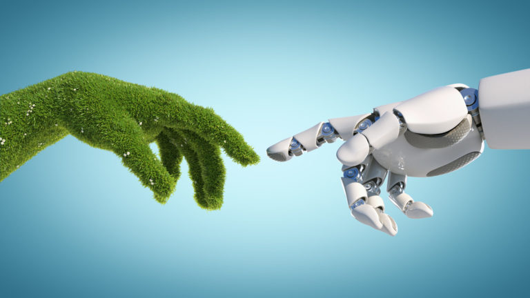 Nature and technology abstract concept, robot hand and natural hand covered with grass