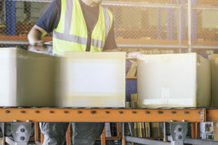 Worker is sorting package boxes on conveyor belt, cartons, cardboard boxes, delivering shipment parcels,
