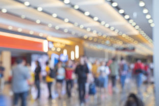 Blurred,defocused background of Crowd in trade event exhibition hall. Business trade show,shopping mall and marketing advertisement concept,MICE industry business concept