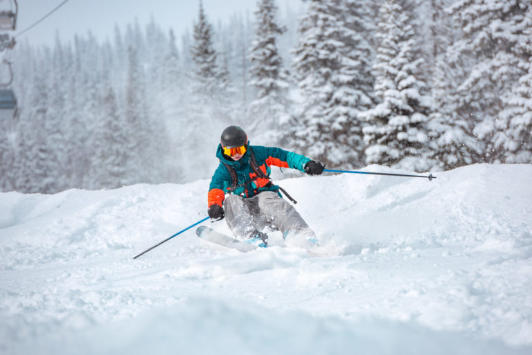 Freeride skier at off piste slope in forest