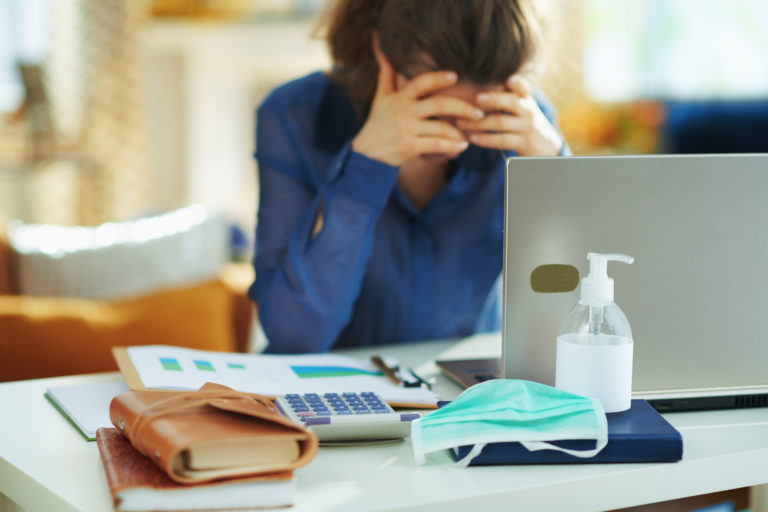 Medical mask and hand disinfectant and stressed woman