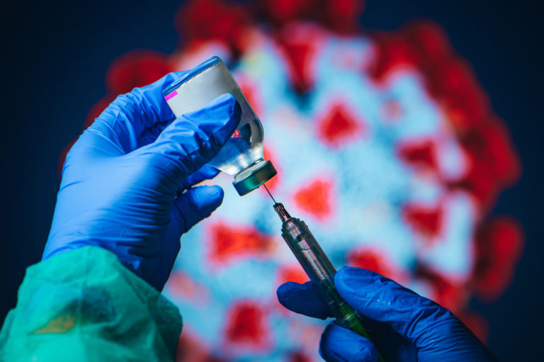 Coronavirus Covid 19 Protection and Vaccine. Doctor drawing up solution from vaccine bottle and filling syringe injection for patient vaccination in medical clinic, Coronavirus in background