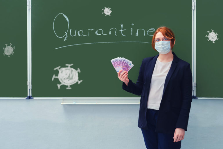 Woman teacher in a medical mask holds money in euros at the blackboard with the words "Quarantine". Concept of money problems during isolation due to flu virus.