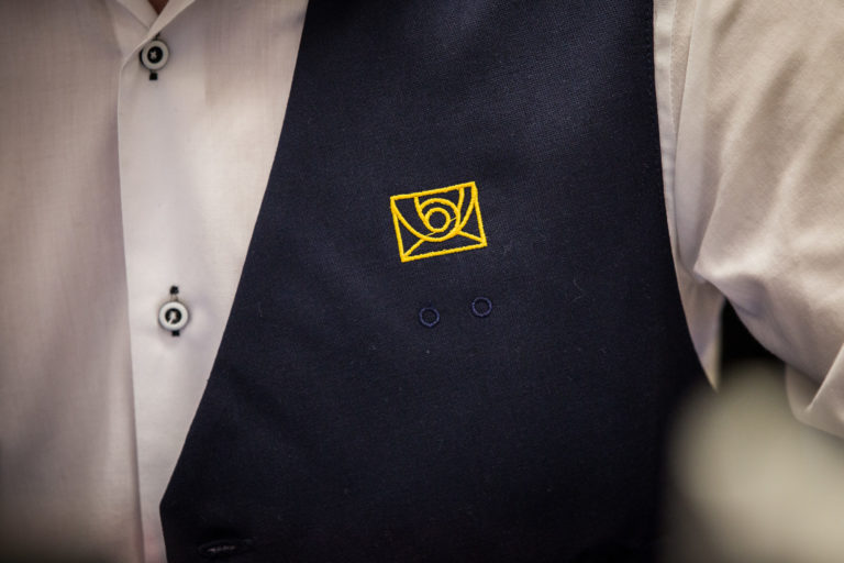 Logo spoločnosti Slovenská pošta na veste pracovníka. Bratislava, 14. január 2016.