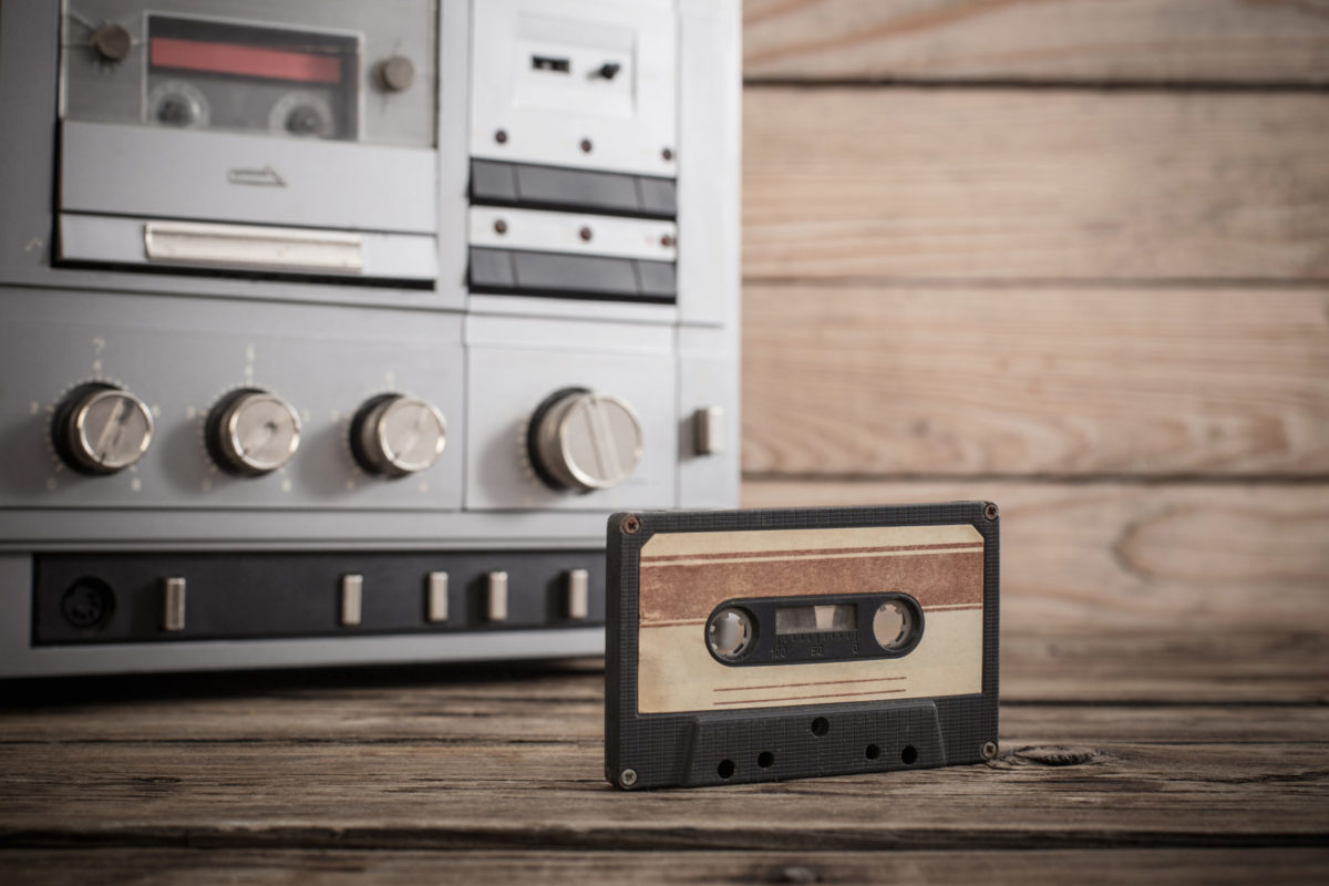 Old tape recorder and cassette on wooden background