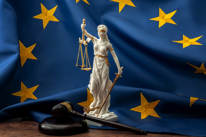 European union court of justice or ECJ, legal system in Europe and the legislature branch of government concept with a gavel, a statue of Themis the lady of justice and the EU flag