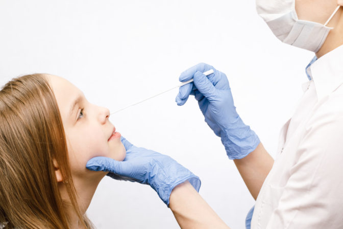Pediatrician taking nasal mucus test sample