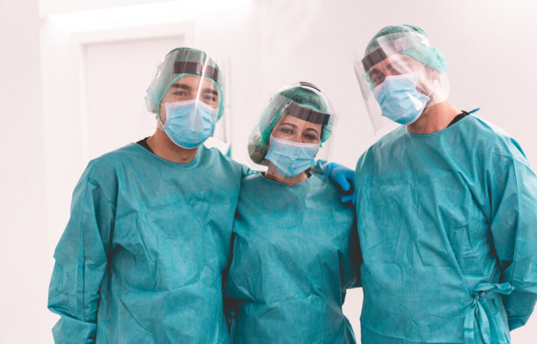 Medical workers inside hospital corridor during coronavirus pandemic outbreak - Doctor and nurse at work on Covid 19 crisis period - Health care concept - Main focus on center woman face