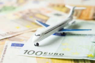 Toy airplane on a euro currency, air travel concept. Close up, selective focus.