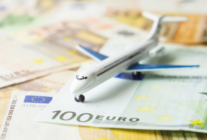 Toy airplane on a euro currency, air travel concept. Close up, selective focus.