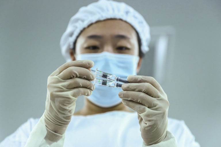 FILE - In this Dec. 25, 2020 file photo, released by Xinhua News Agency, a staff member inspects syringes of COVID-19 inactivated vaccine products at a packaging plant of the Beijing Biological Products Institute Co., Ltd, a unit of state-owned Sinopharm in Beijing. China has given conditional approval to a coronavirus vaccine developed by state-owned Sinopharm. The vaccine is the first one approved for general use in China.
