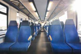 German train interior with two rows of empty seats and sunlight