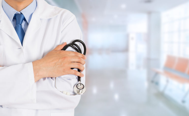 Doctor standing with his arms folded inside