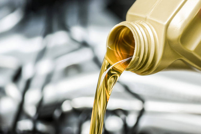 Woman hand pour motor oil to car engine.