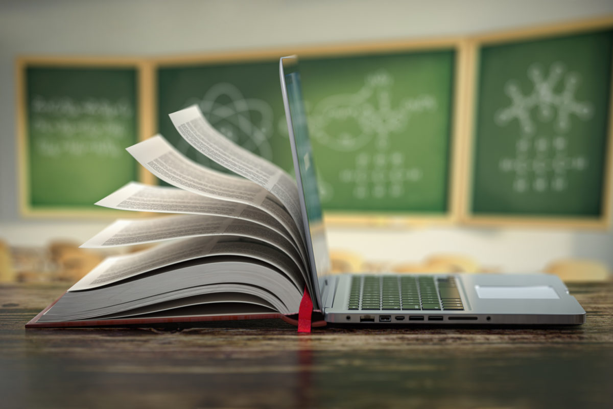 E learning online education or internet  encyclopedia concept. Open laptop and book compilation in a classroom.