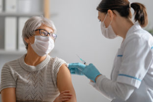 Doctor giving a senior woman a vaccination