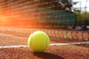 Symbolic image: Tennis court with ball and net, close up