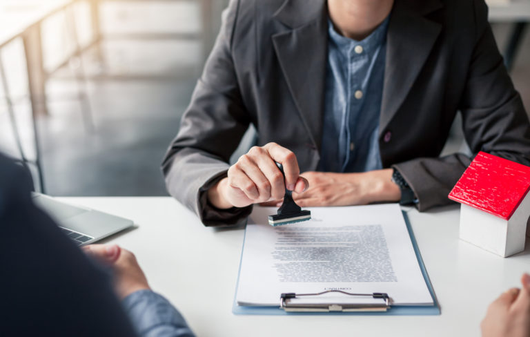 Business people approval stamp on business contract. Approval of a contract to buy or sell a home. Offers mortgage loans and home insurance concept.
