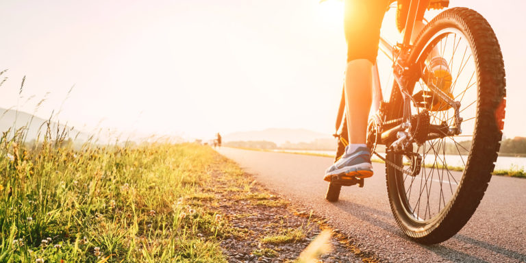 Woman feet on bycikle pedal in sunset light