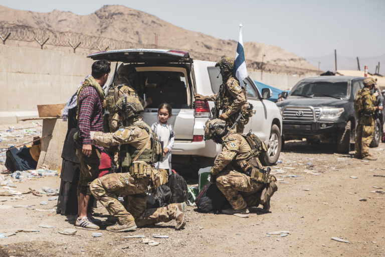 Afghanistan Republicans Refugees In this image provided by the U.S. Marine Corps, Finnish coalition forces assist evacuees for onward processing during an evacuation at Hamid Karzai International Airport in Kabul, Afghanistan, on Tuesday, Aug. 24, 2021. As the U.S. rushes to evacuate Americans and allies from Afghanistan, a growing number of Republicans are questioning why the U.S. should take in Afghan citizens who worked side by side with Americans.