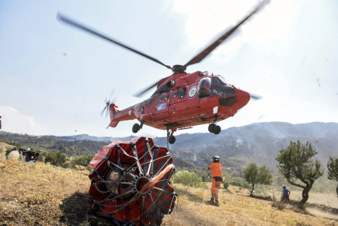 A firefighting helicopter prepares to take water from a lake in Akcaova Village, near Cine, Aydin, Turkey, Saturday, Aug. 7, 2021. In Turkey's seaside province of Mugla, most fires appeared to be under control Saturday. Municipalities in Marmaris and the wider Mugla province said cooling efforts were ongoing in areas where fires were brought under control.()