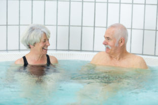 Senior couple resting in jacuzzi in spa resort